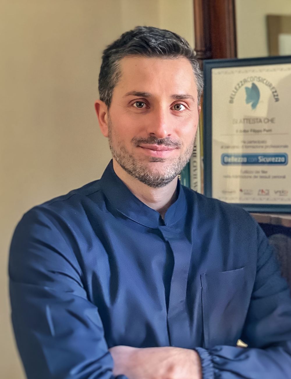 Il Dott. Filippo Perri, in camice blu, a braccia conserte